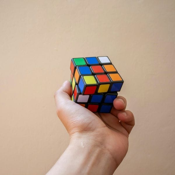 A hand holding up a scrambled Rubik's cube
